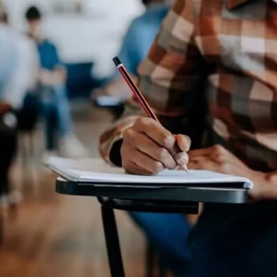 Estudante segura celular com aplicativo Caixa Tem aberto
