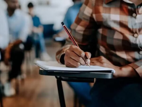 Estudante segura celular com aplicativo Caixa Tem aberto