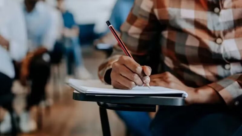 Estudante segura celular com aplicativo Caixa Tem aberto