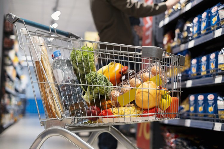 Consumidores fazendo compras em supermercado com prateleiras de alimentos