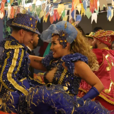 Quadrilha junina se apresenta em shopping com roupas típicas e decoração colorida