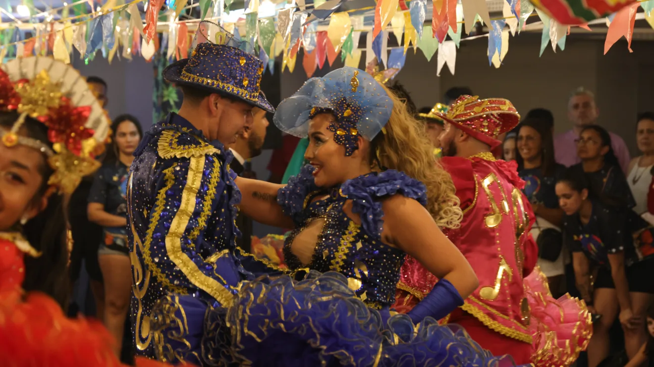 Quadrilha junina se apresenta em shopping com roupas típicas e decoração colorida