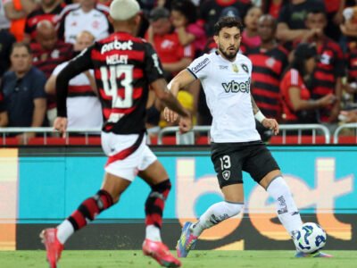Imagem de Alex Telles em campo durante o empate entre Botafogo e Flamengo no Maracanã. Lateral-esquerdo demonstra foco e liderança na partida