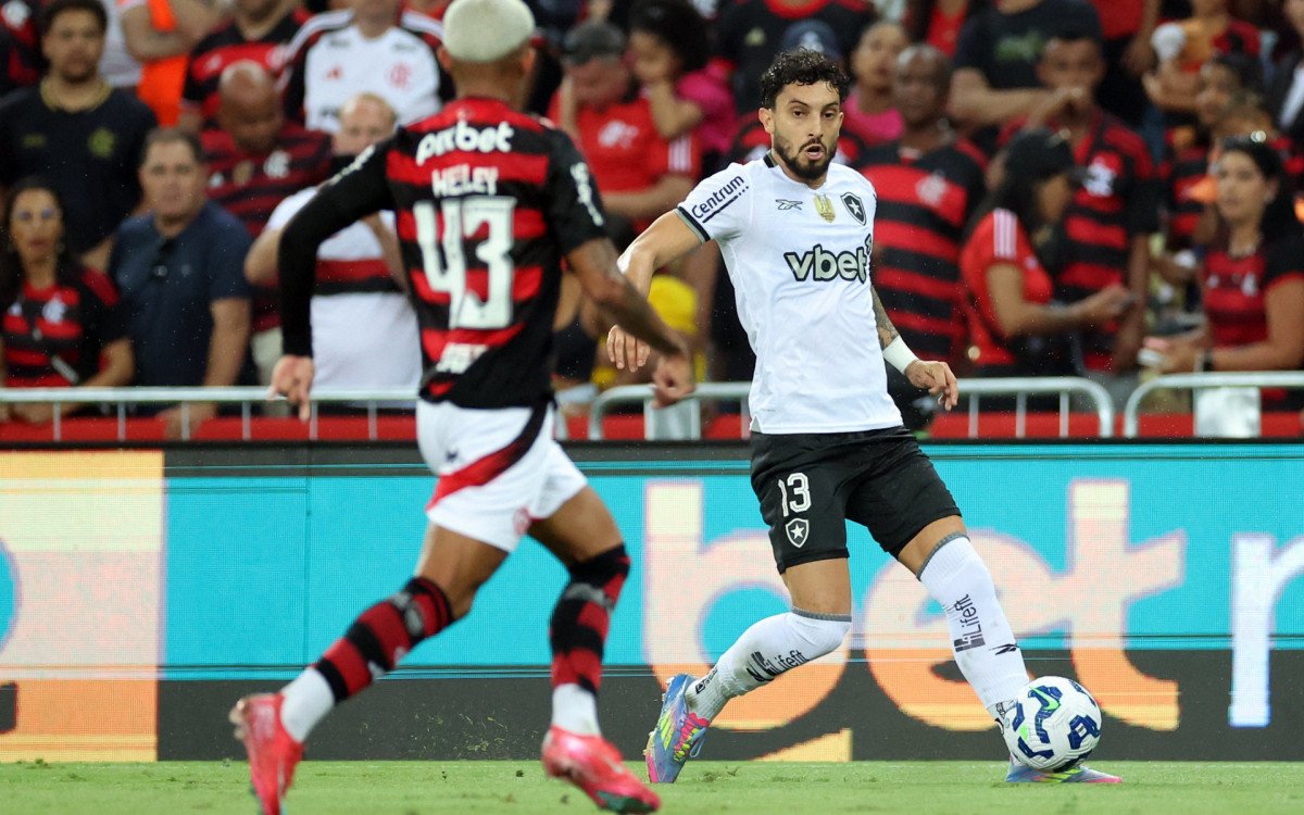Imagem de Alex Telles em campo durante o empate entre Botafogo e Flamengo no Maracanã. Lateral-esquerdo demonstra foco e liderança na partida