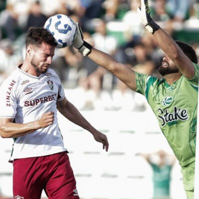 Jogador do Fluminense disputa bola aérea com goleiro do Juventude durante partida do Brasileirão