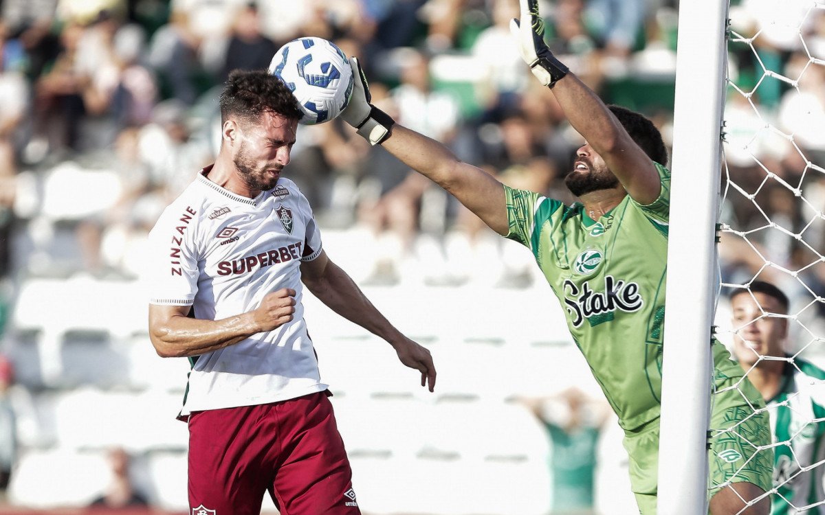 Jogador do Fluminense disputa bola aérea com goleiro do Juventude durante partida do Brasileirão