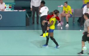 Foto de Tamires Morena carregando a adversária lesionada durante jogo de handebol nas Olimpíadas de Paris