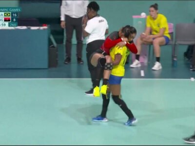 Foto de Tamires Morena carregando a adversária lesionada durante jogo de handebol nas Olimpíadas de Paris