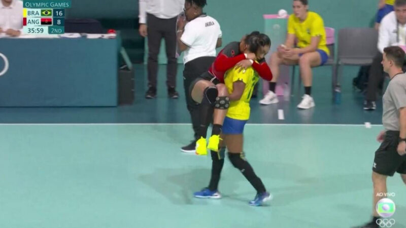 Foto de Tamires Morena carregando a adversária lesionada durante jogo de handebol nas Olimpíadas de Paris