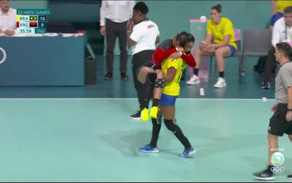 Foto de Tamires Morena carregando a adversária lesionada durante jogo de handebol nas Olimpíadas de Paris