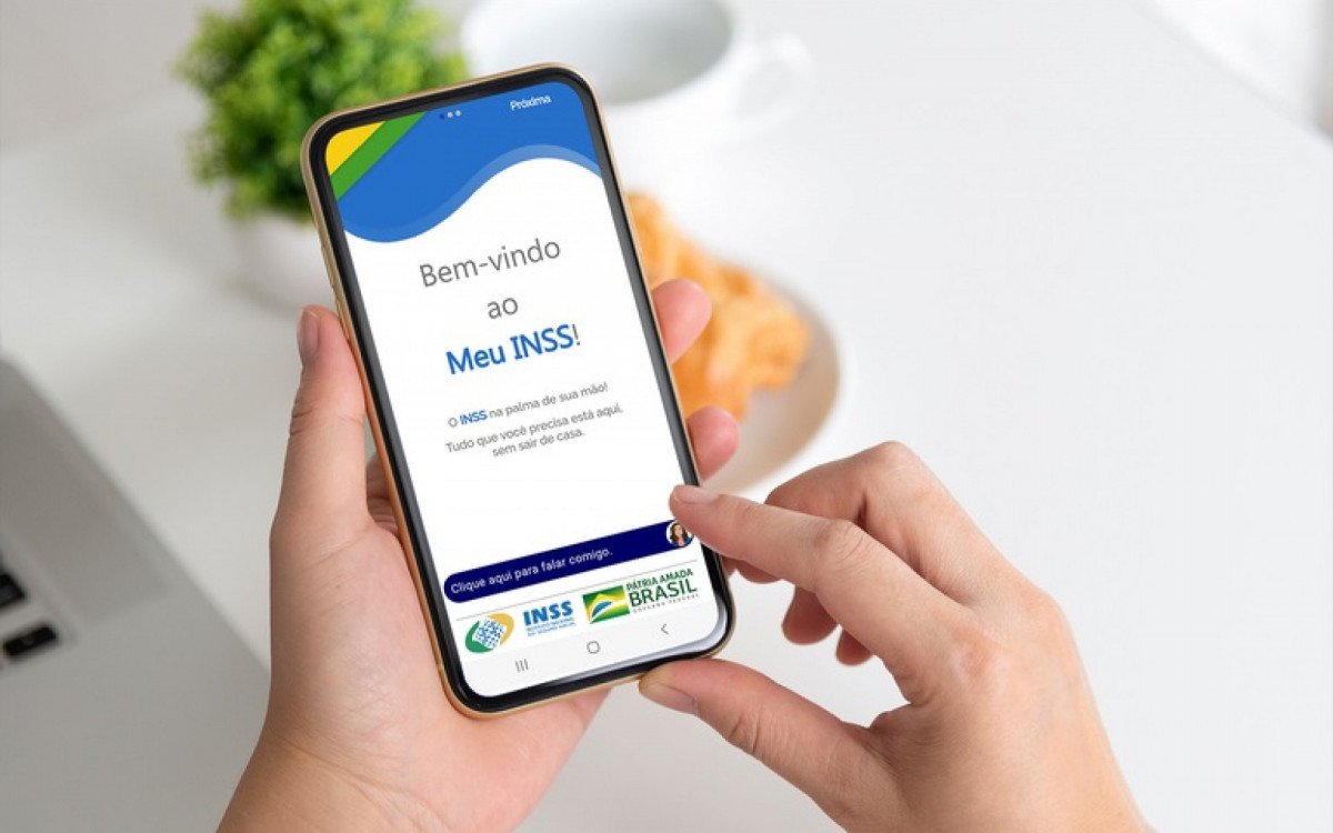 Pessoa acessando o aplicativo Meu INSS pelo celular para solicitar indenização por síndrome do zika vírus