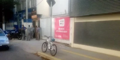 Imagem do local da tragédia com trabalhadores visivelmente abalados após morte de colega em obra escolar