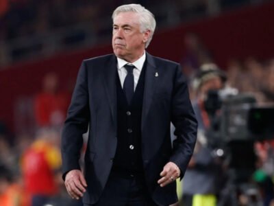Técnico Carlo Ancelotti, de terno, à beira do campo durante jogo do Real Madrid