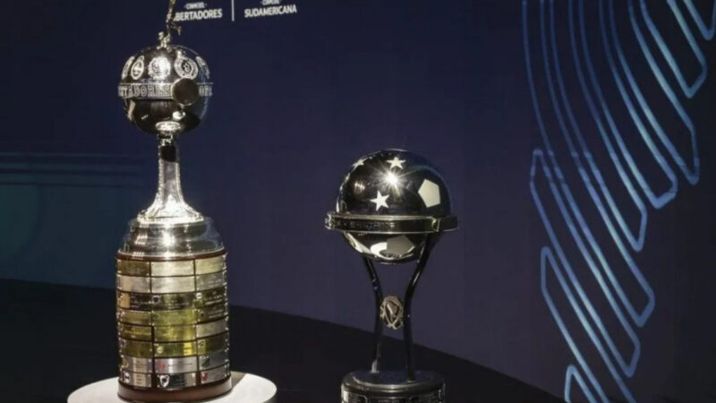 Imagem ilustrativa dos troféus da Libertadores e Sul-Americana com fundo da sede da Conmebol
