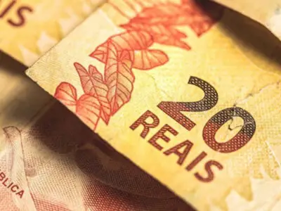 Cartão do Bolsa Família sobre notas de real; pagamentos de junho são finalizados pela Caixa