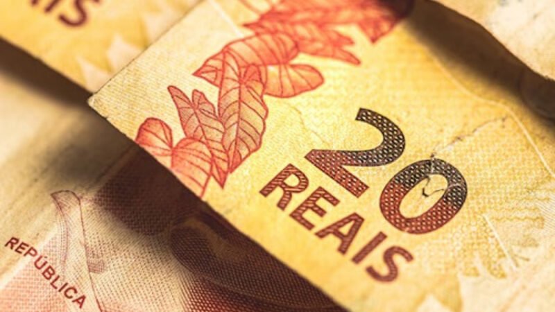 Cartão do Bolsa Família sobre notas de real; pagamentos de junho são finalizados pela Caixa
