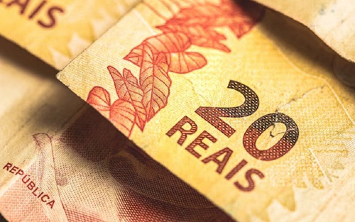 Cartão do Bolsa Família sobre notas de real; pagamentos de junho são finalizados pela Caixa