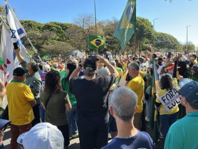 Manifestantes bolsonaristas em Copacabana com cartazes e roupas verde-amarelas pedindo ajuda internacional