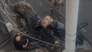 Agentes da Polícia Civil socorrem motociclista baleado durante operação em Manguinhos, no Rio de Janeiro