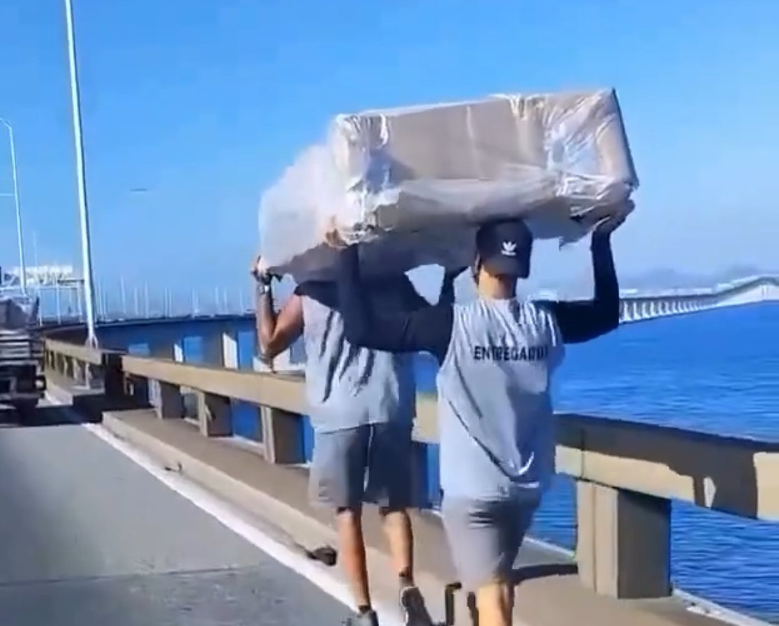 Homens tentam carregar sofá em meio ao trânsito na Ponte Rio-Niterói