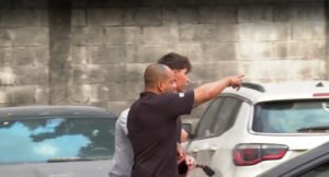 Acompanhado por policiais civis, Luan Plácido, ex-jogador do Botafogo deixa IML após realizar exame ao passo que médica cita em laudo o comportamento do atleta e atesta o "uso de substâncias" | Reprodução TV Globo