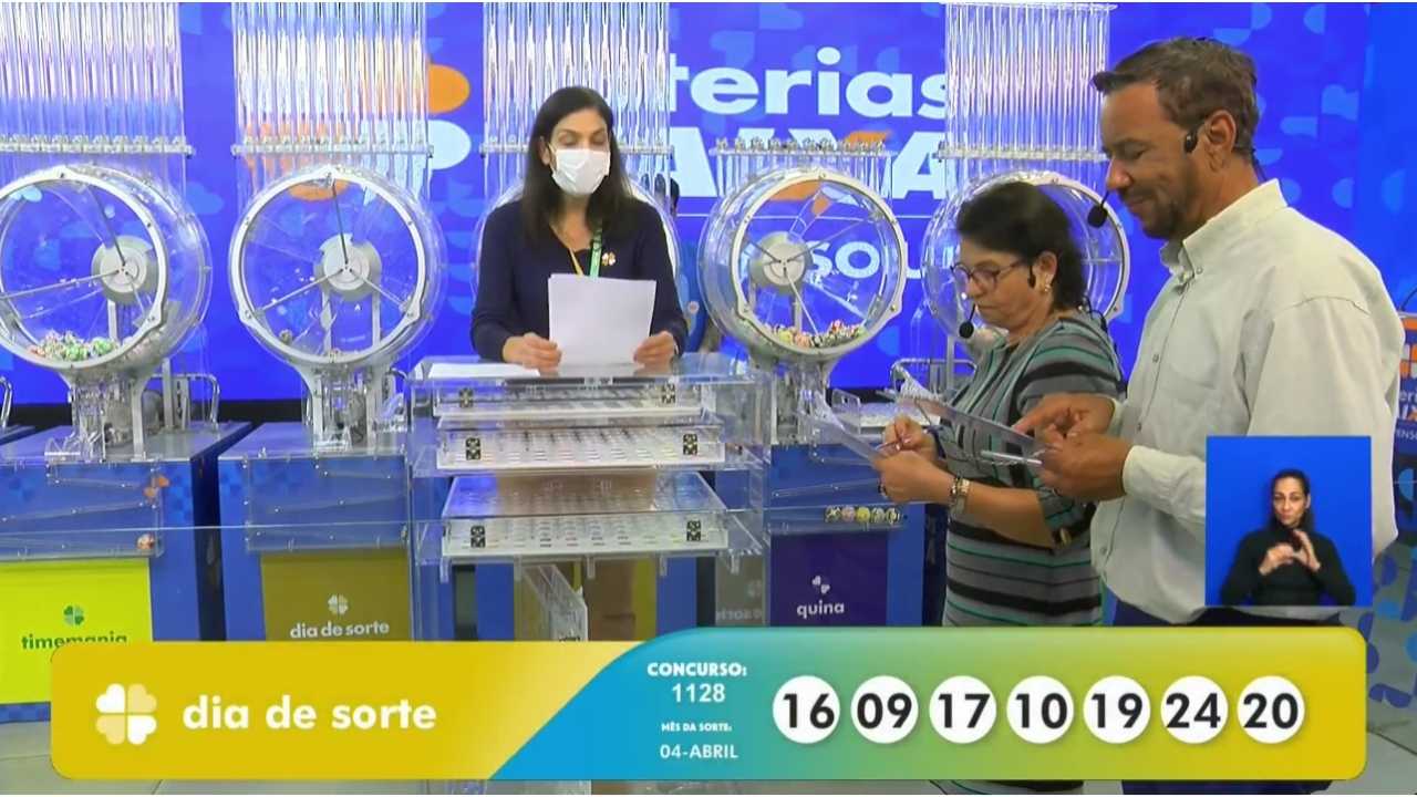 Ao final do sorteio, auditores do público, juntamente com uma funcionária da Loterias Caixa, realizam a conferência do resultado, assinando a ata que valida o concurso 1128 da Dia de Sorte | Reprodução/Youtube/Loterias Caixa