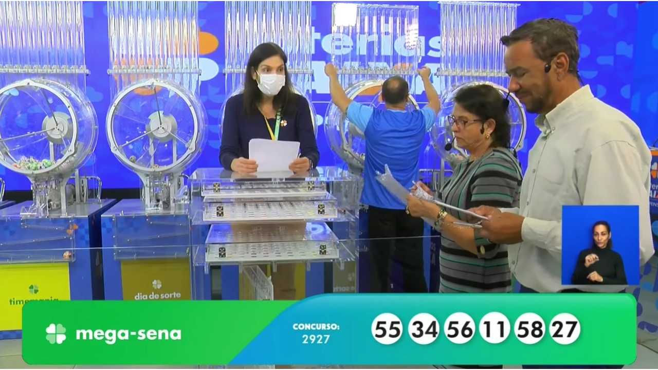 Ao final do sorteio, auditores do público, juntamente com uma funcionária da Loterias Caixa, realizam a conferência do resultado, assinando a ata que valida o concurso 2927 da Mega-Sena | Reprodução/Youtube/Loterias Caixa