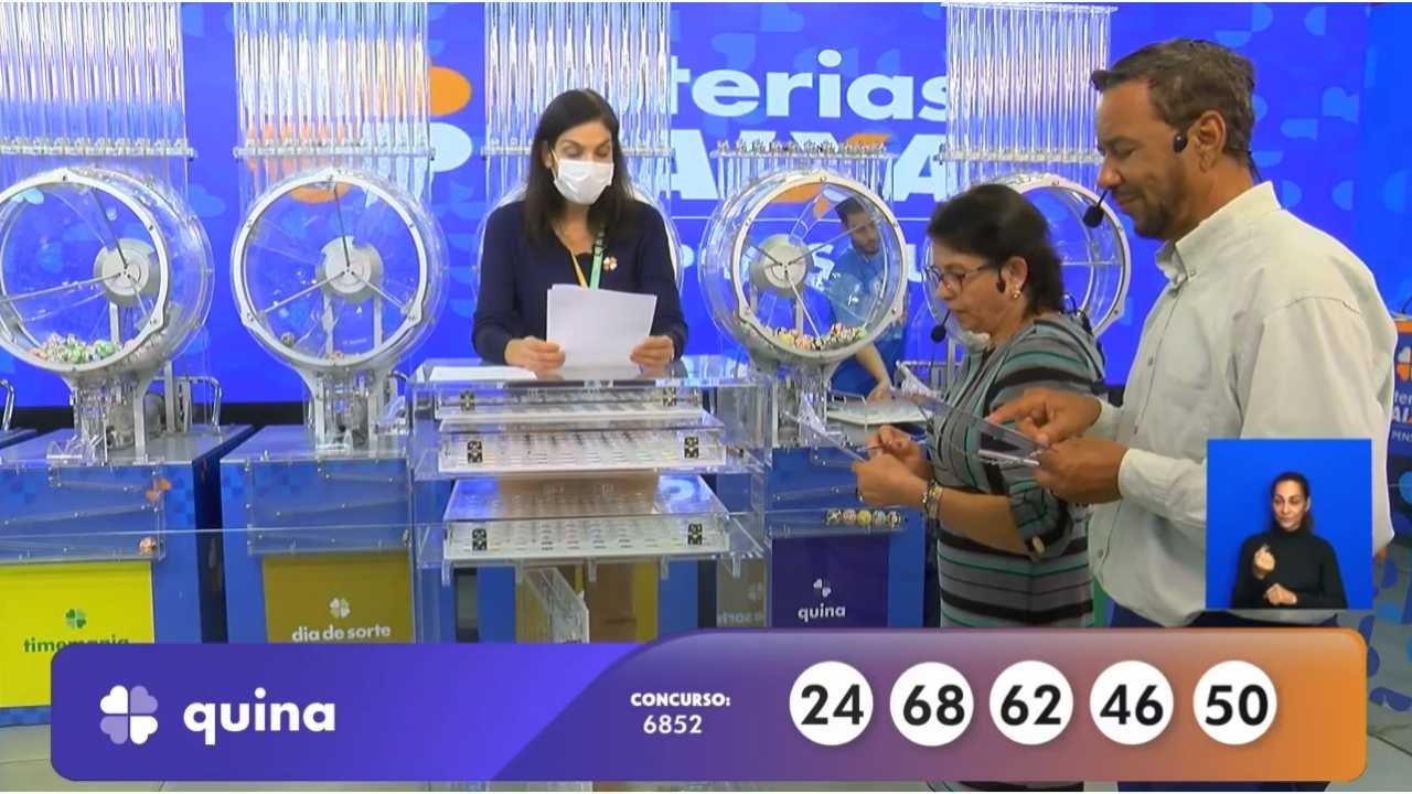Ao final do sorteio, auditores do público, juntamente com uma funcionária da Loterias Caixa, realizam a conferência do resultado, assinando a ata que valida o concurso 6852 da Quina | Reprodução/Youtube/Loterias Caixa