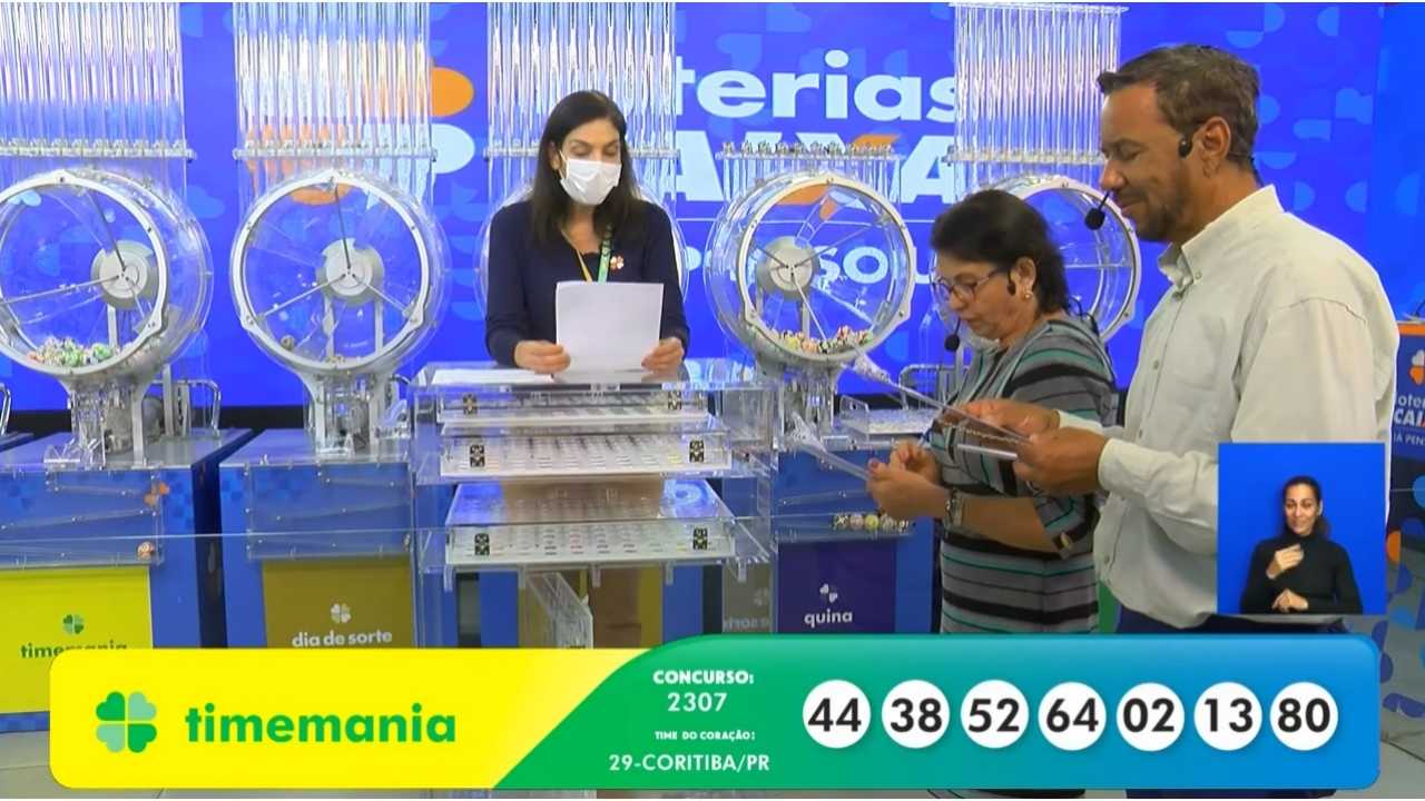 Ao final do sorteio, auditores do público, juntamente com uma funcionária da Loterias Caixa, realizam a conferência do resultado, assinando a ata que valida o concurso 2307 da Timemania | Reprodução/Youtube/Loterias Caixa