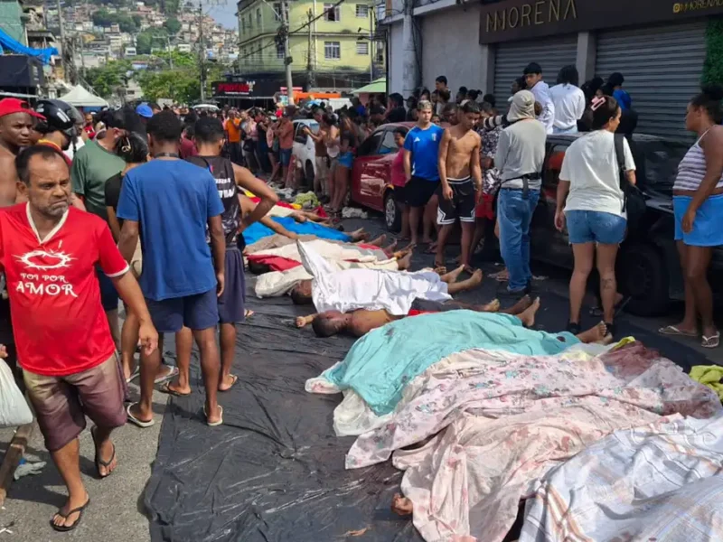 Moradores se aglomeram diante dos corpos estendidos nas ruas da Penha após a Operação Contenção, em uma cena de choque coletivo que expõe a dimensão da letalidade e o impacto imediato da ação policial no território
