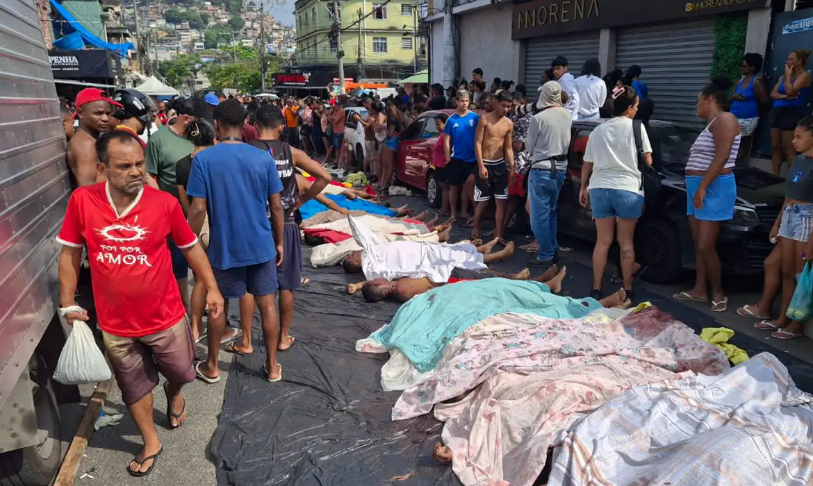 Moradores se aglomeram diante dos corpos estendidos nas ruas da Penha após a Operação Contenção, em uma cena de choque coletivo que expõe a dimensão da letalidade e o impacto imediato da ação policial no território