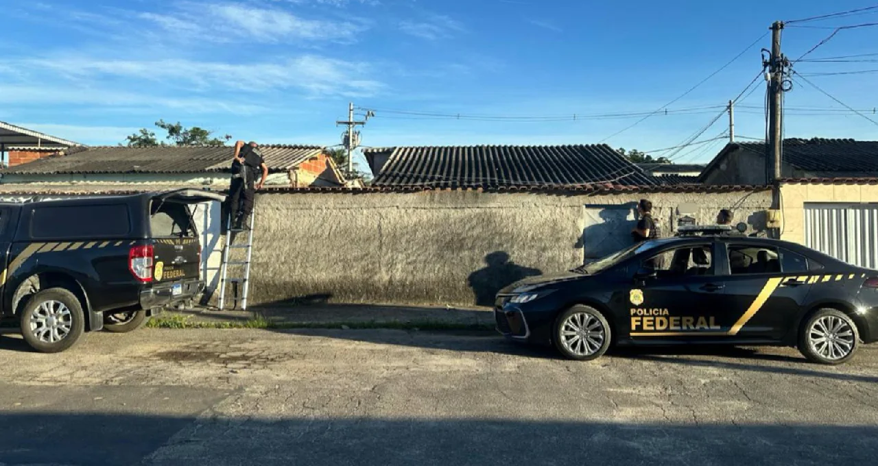Policiais federais sobem escada e inspecionam o telhado de residência durante operação contra fraude.