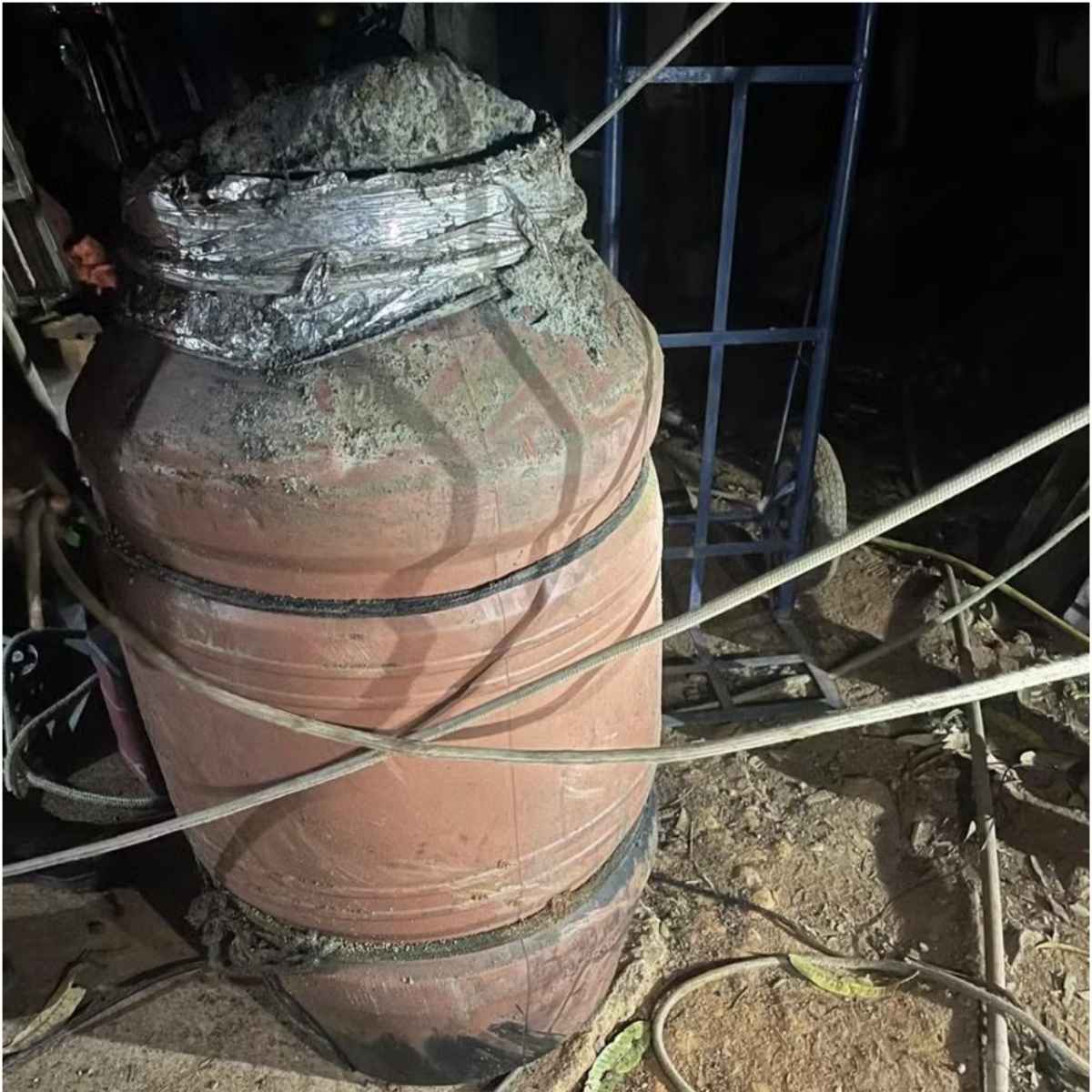 Barril plástico (tambor) onde o corpo de Rosa Maria foi encontrado pelos agentes da DHNSG. O recipiente estava selado com uma espessa camada de concreto, exigindo o uso de equipamentos específicos para a remoção do cadáver. (Foto: Divulgação/Polícia Civil)