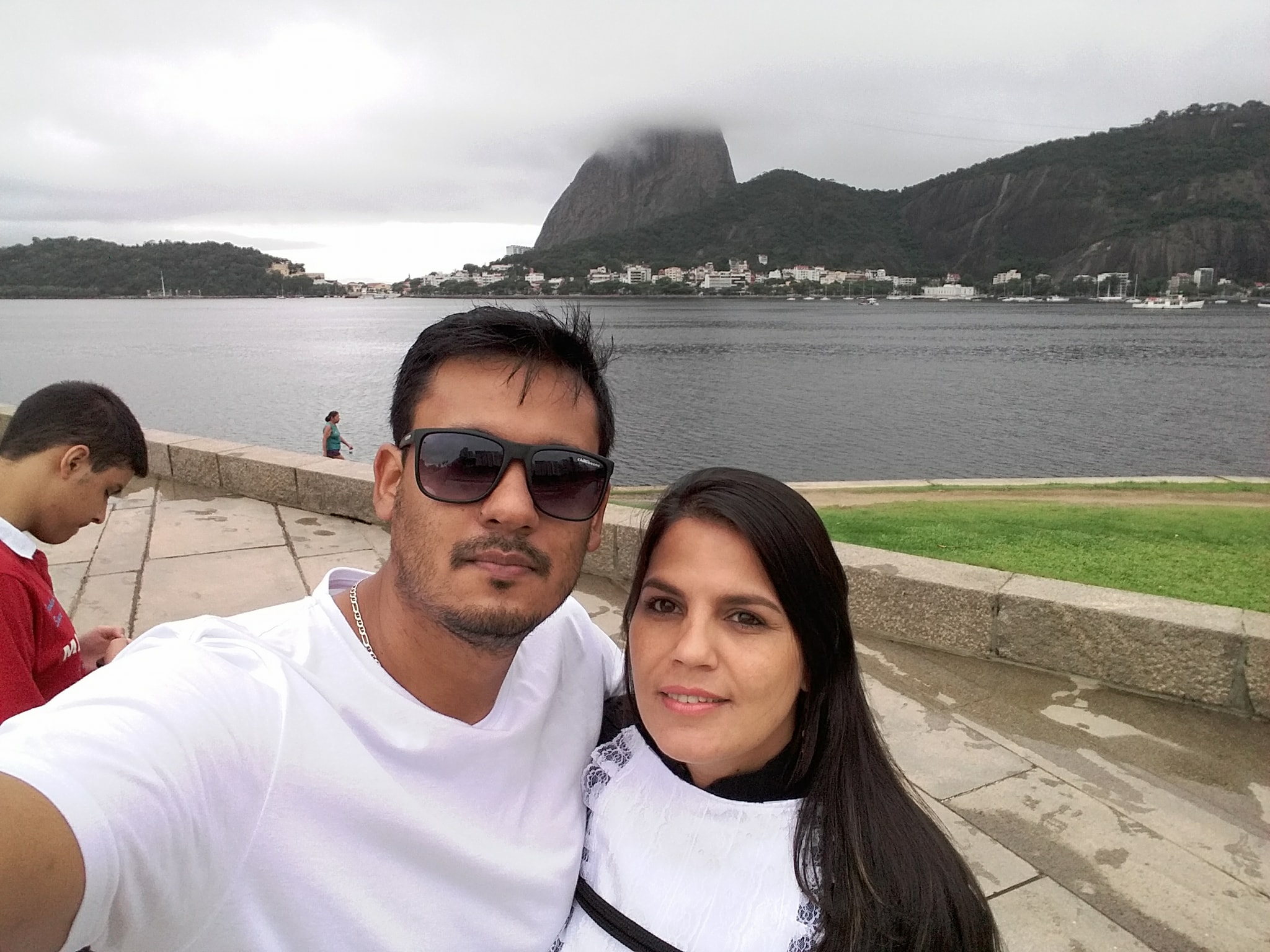 Fred Santos abraçado a Cinthia, com a Baía de Guanabara ao fundo | Reprodução Redes Sociais