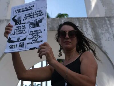 Manifestantes seguram cartazes contra a violência contra LGBTQIA+ e feminicídio nos Arcos da Lapa, Rio de Janeiro.