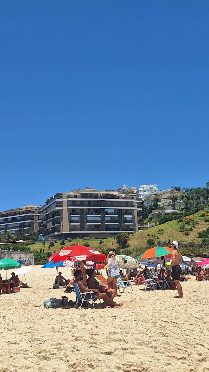 Banhistas na areia da Praia de Piratininga aproveitando o calor de 32°C da Previsão do tempo para Niterói: sexta-feira, 26 de dezembro de 2025.