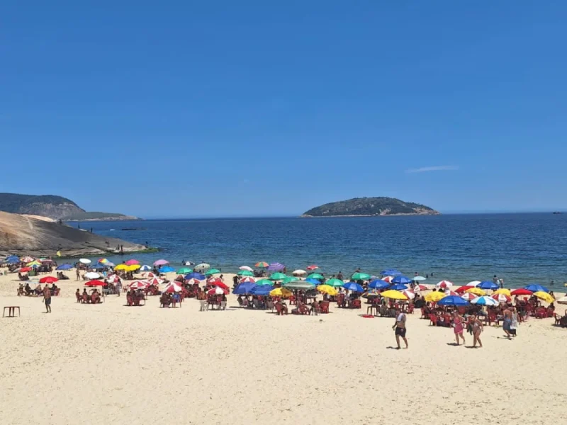 Praia de Piratininga lotada sob sol forte para ilustrar a Previsão do tempo para Niterói: sexta-feira, 26 de dezembro de 2025.