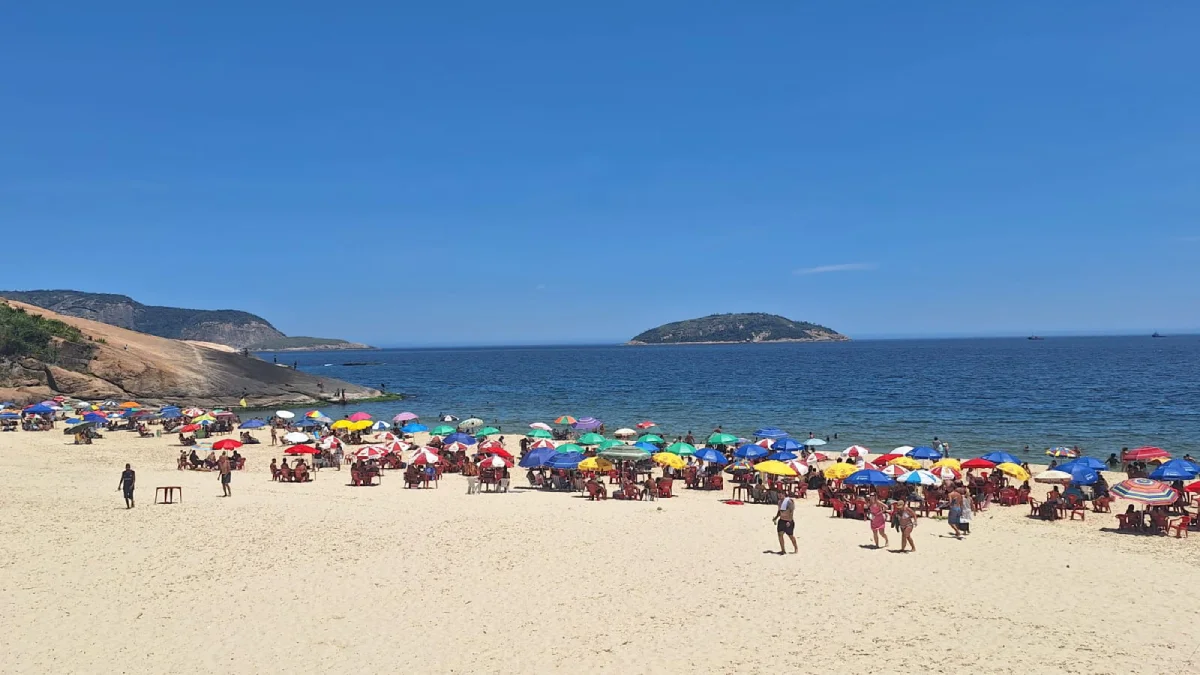 Praia de Piratininga lotada sob sol forte para ilustrar a Previsão do tempo para Niterói: sexta-feira, 26 de dezembro de 2025.