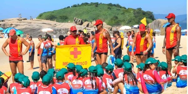 Crianças participam de simulação de primeiros socorros durante as inscrições do Projeto Botinho 2026 em Niterói e Maricá, com orientação direta dos guarda-vidas.