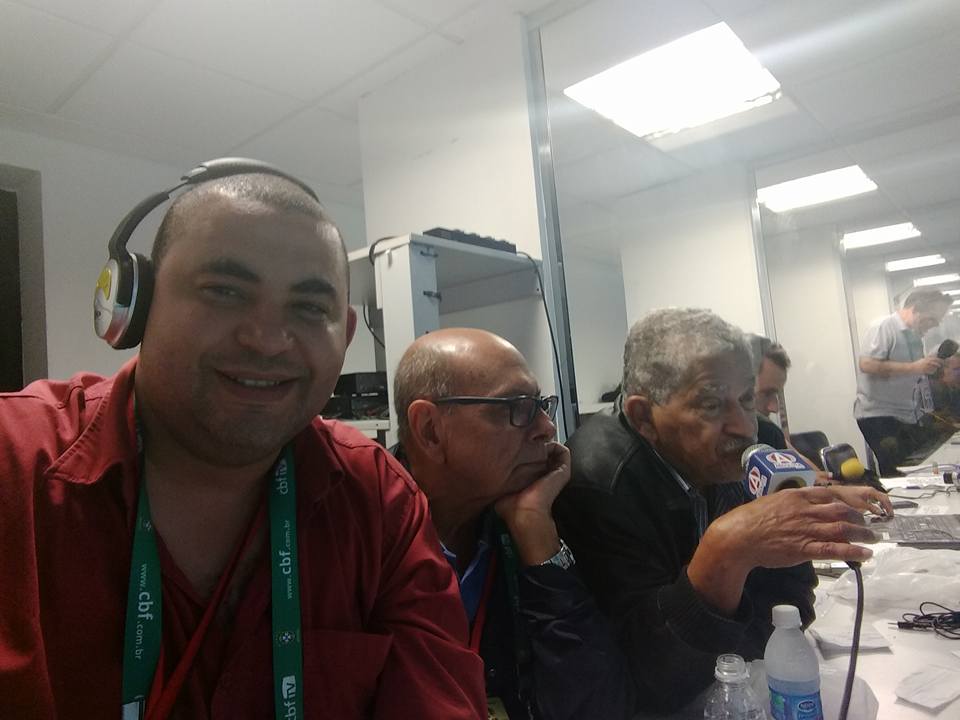 Transmissão esportiva de Brasil 3 x 0 Paraguai, em 29 de março de 2017, na Arena Corinthians, ocasião em que o Brasil se classificou para a Copa do Mundo da Rússia: enquanto Paulo reporta o jogo, um raro sorriso do então narrador André e Antonio Maia, comentarista, entre ambos | Acervo de Família