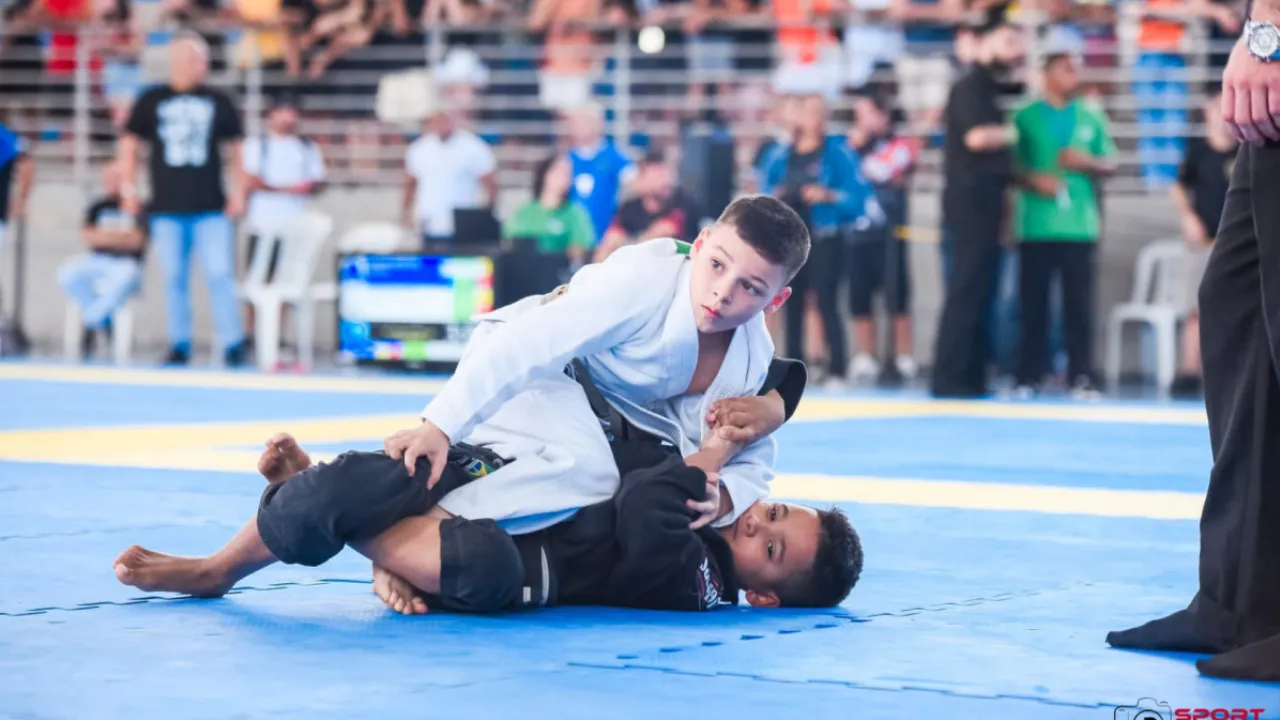 Atletas de Jiu-Jitsu em competição durante disputa no tatame Atletas de Jiu-Jitsu em competição durante disputa no tatame