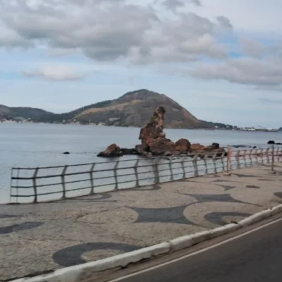 Orla de Niterói durante período de vento, com árvores e vegetação movimentadas pelas rajadas e o mar ao fundo. O município recebeu novo alerta de ventos costeiros às 8h30 deste domingo e permanece também sob aviso de vendaval