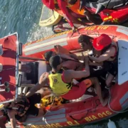 Agentes do Corpo de Bombeiros a bordo de bote inflável vermelho BIA 016 resgatam homem na Baía de Guanabara
