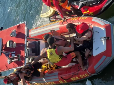 Agentes do Corpo de Bombeiros a bordo de bote inflável vermelho BIA 016 resgatam homem na Baía de Guanabara