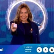 Imagem mostra garota da sorte com a última bola do resultado completo e prêmios do concurso 6082 da Loteria Federal, referente à Extração de sábado, 11/07, com todas as dezenas de milhar do 1º, 2º, 3º, 4º, 5º prêmio