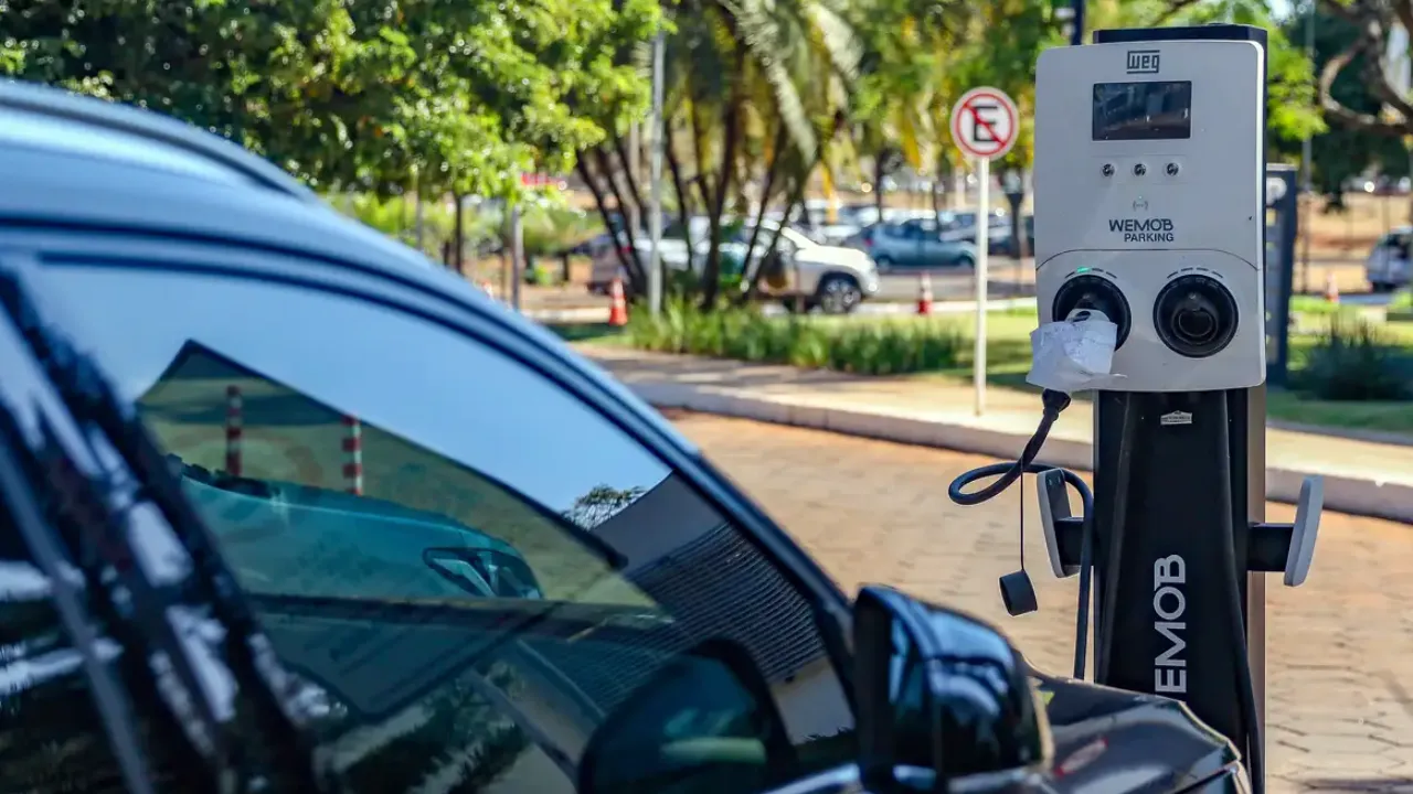 Carro elétrico conectado a eletroposto em via urbana do Rio de Janeiro