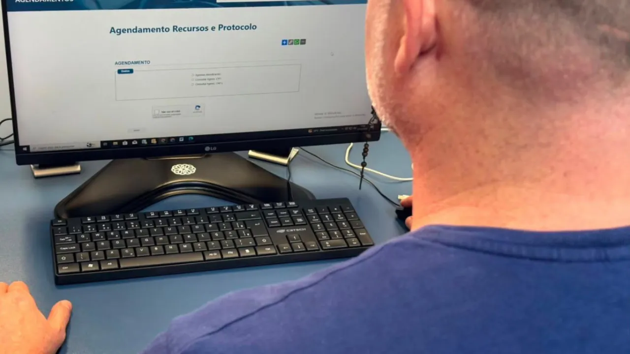 Pessoa confere comprovante de pagamento de taxa do Detran RJ em atendimento de serviço público Pessoa confere comprovante de pagamento de taxa do Detran RJ em atendimento de serviço público