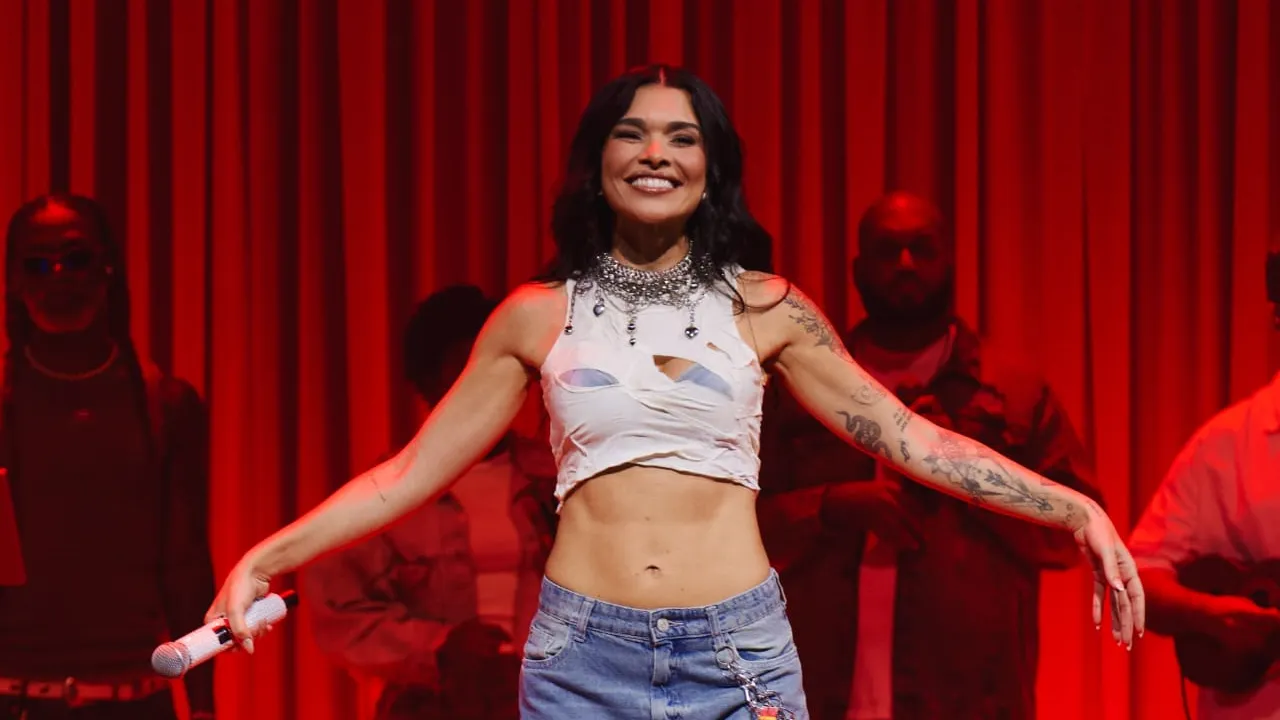 Cantora Lary em apresentação musical ao vivo, relacionada à gravação do audiovisual Com Calor em Niterói