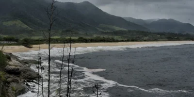Imagem jornalística sobre a previsão do tempo em Maricá nesta segunda-feira, marcada por temperaturas mais baixas, alta umidade, céu fechado e possibilidade de chuva