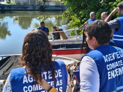 Agente de endemias vistoria recipiente em área próxima à orla de Bambuí, em Maricá